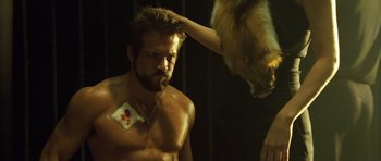 Movie still from “Blade: Trinity” (2004), directed by David S. Goyer – A man with no shirt and no shirt is getting his hair cut by a woman with no shirt; Close Up shot, Over the shoulder angle