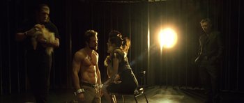 Movie still from “Blade: Trinity” (2004), directed by David S. Goyer – A man and a woman are sitting on a chair in front of a light; Medium shot, Over the shoulder angle