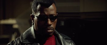 Movie still from “Blade: Trinity” (2004), directed by David S. Goyer – A person wearing sunglasses and a leather jacket; Close Up shot, Low angle