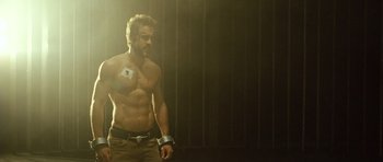 Movie still from “Blade: Trinity” (2004), directed by David S. Goyer – A shirtless man with a bandage on his chest; Medium shot, Over the shoulder angle