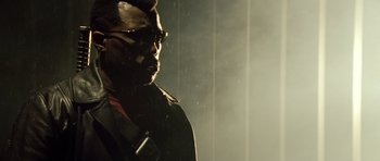 Movie still from “Blade: Trinity” (2004), directed by David S. Goyer – A man in a black jacket and sunglasses is standing in the rain; Close Up shot, Low angle
