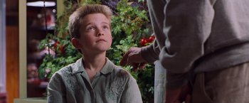 Movie still from “Blast from the Past” (1999), directed by Hugh Wilson – A young boy looking up at a man; Close Up shot, Over the shoulder angle