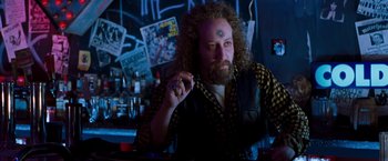 Movie still from “Blast from the Past” (1999), directed by Hugh Wilson – A man sitting at a table in front of a bar; Close Up shot, Low angle