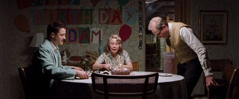 Movie still from “Blast from the Past” (1999), directed by Hugh Wilson – An older woman sitting in front of a birthday cake; Wide shot, Over the shoulder angle