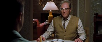 Movie still from “Blast from the Past” (1999), directed by Hugh Wilson – A man sitting at a table with a plate of food in front of him; Medium shot, Over the shoulder angle