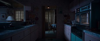 Movie still from “Blast from the Past” (1999), directed by Hugh Wilson – A kitchen with a table and chairs in the doorway; Extreme Wide shot, High angle