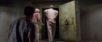 Movie still from “Blast from the Past” (1999), directed by Hugh Wilson – A man and a woman are standing in front of an open door; Medium shot, Over the shoulder angle