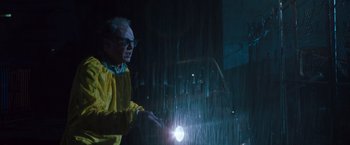 Movie still from “Blast from the Past” (1999), directed by Hugh Wilson – A man in a yellow raincoat holding a flashlight in the rain; Medium shot, Low angle