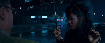 Movie still from “Blast from the Past” (1999), directed by Hugh Wilson – A woman holding an umbrella while standing in the rain; Close Up shot, Over the shoulder angle