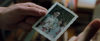 Movie still from “Blast from the Past” (1999), directed by Hugh Wilson – A person holding a picture of a man and woman; Extreme Close Up shot, Over the shoulder angle