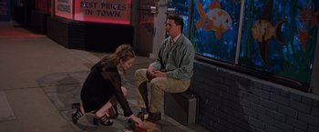 Movie still from “Blast from the Past” (1999), directed by Hugh Wilson – A man and a woman sitting on a bench; Wide shot, High angle