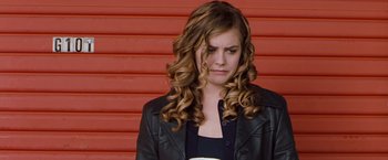 Movie still from “Blast from the Past” (1999), directed by Hugh Wilson – A woman in a leather jacket is holding a coffee cup; Medium shot, Low angle