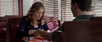 Movie still from “Blast from the Past” (1999), directed by Hugh Wilson – A woman sitting at a table with another woman; Medium shot, Over the shoulder angle