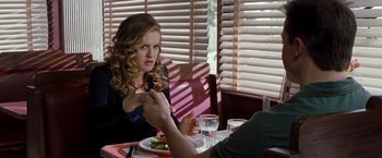 Movie still from “Blast from the Past” (1999), directed by Hugh Wilson – A woman sitting at a dinner table with a man; Medium shot, Over the shoulder angle