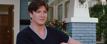 Movie still from “Blast from the Past” (1999), directed by Hugh Wilson – A young man in a black shirt posing for a picture; Close Up shot, Over the shoulder angle