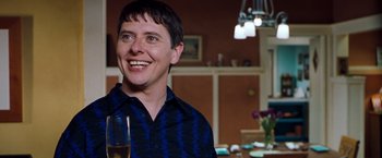 Movie still from “Blast from the Past” (1999), directed by Hugh Wilson – A man smiling while holding a glass of wine; Close Up shot, Over the shoulder angle