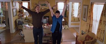 Movie still from “Blast from the Past” (1999), directed by Hugh Wilson – Two young men standing next to each other in a living room; Wide shot, Low angle