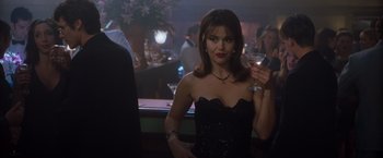 Movie still from “Blast from the Past” (1999), directed by Hugh Wilson – A woman in a strapless dress holding a glass of wine; Medium shot, Over the shoulder angle