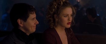 Movie still from “Blast from the Past” (1999), directed by Hugh Wilson – Two people sitting in front of each other in a dark room; Close Up shot, Over the shoulder angle