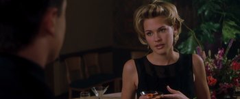 Movie still from “Blast from the Past” (1999), directed by Hugh Wilson – A woman sitting at a table with a bowl of food in front of her; Close Up shot, Over the shoulder angle