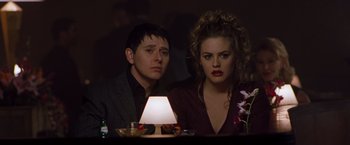 Movie still from “Blast from the Past” (1999), directed by Hugh Wilson – A man and a woman sitting next to each other at a table; Medium shot, Over the shoulder angle