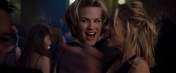 Movie still from “Blast from the Past” (1999), directed by Hugh Wilson – Two young women laughing together at a party; Close Up shot, Over the shoulder angle