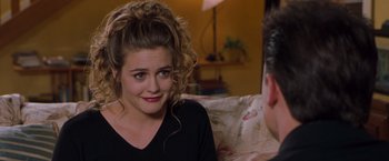 Movie still from “Blast from the Past” (1999), directed by Hugh Wilson – A woman sitting in front of a man on a couch; Close Up shot, Over the shoulder angle