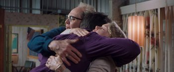 Movie still from “Blast from the Past” (1999), directed by Hugh Wilson – A group of people hugging each other in a room; Medium shot, Low angle