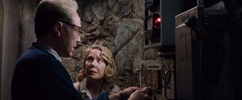 Movie still from “Blast from the Past” (1999), directed by Hugh Wilson – An older man and a woman looking at an electronic device; Medium shot, Low angle