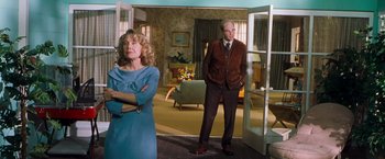 Movie still from “Blast from the Past” (1999), directed by Hugh Wilson – A man and a woman standing in front of an open door; Wide shot, Low angle