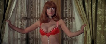 Movie still from “Blazing Saddles” (1974), directed by Mel Brooks – A woman wearing a red bra and a necklace; Medium shot, Low angle