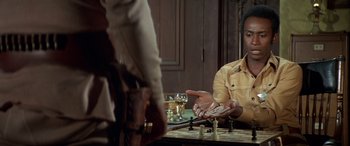 Movie still from “Blazing Saddles” (1974), directed by Mel Brooks – A man sitting in front of a chess board; Close Up shot, Over the shoulder angle