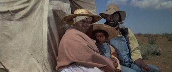 Movie still from “Blazing Saddles” (1974), directed by Mel Brooks – A group of people wearing hats and a blanket; Medium shot, Low angle