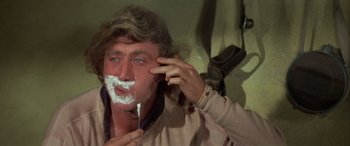 Movie still from “Blazing Saddles” (1974), directed by Mel Brooks – A man shaving his face with a razor blade; Close Up shot, Over the shoulder angle