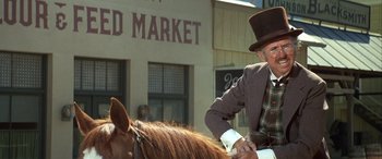 Movie still from “Blazing Saddles” (1974), directed by Mel Brooks – An old man in a top hat is riding a horse; Medium shot, Low angle
