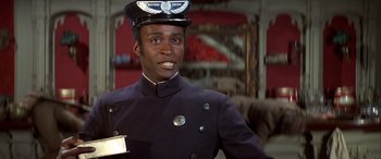 Movie still from “Blazing Saddles” (1974), directed by Mel Brooks – A man in a uniform is smiling for the camera; Close Up shot, Low angle