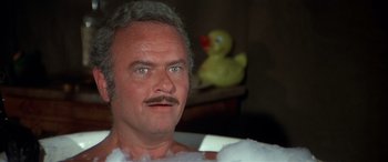 Movie still from “Blazing Saddles” (1974), directed by Mel Brooks – A person sitting in a bathtub; Close Up shot, High angle