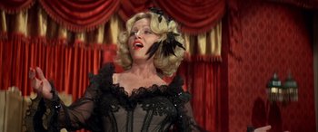 Movie still from “Blazing Saddles” (1974), directed by Mel Brooks – A woman with blonde hair wearing a black dress and a black hat; Close Up shot, Low angle