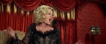 Movie still from “Blazing Saddles” (1974), directed by Mel Brooks – A woman with blonde hair wearing a black dress; Medium shot, Low angle