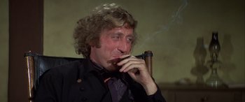 Movie still from “Blazing Saddles” (1974), directed by Mel Brooks – A person holding a cigarette in his mouth; Close Up shot, Low angle