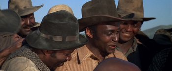 Movie still from “Blazing Saddles” (1974), directed by Mel Brooks – A group of men wearing hats standing next to each other; Close Up shot, Low angle