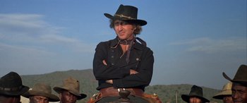 Movie still from “Blazing Saddles” (1974), directed by Mel Brooks – A man in a cowboy hat is sitting on a horse; Medium shot, Low angle