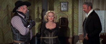 Movie still from “Blazing Saddles” (1974), directed by Mel Brooks – A woman tied up with a rope in a living room; Medium shot, Low angle