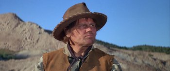 Movie still from “Blazing Saddles” (1974), directed by Mel Brooks – A man wearing a cowboy hat and a vest; Close Up shot, Low angle