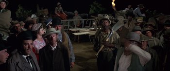 Movie still from “Blazing Saddles” (1974), directed by Mel Brooks – A group of men in old time clothing walking in the dark; Medium shot, High angle