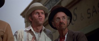 Movie still from “Blazing Saddles” (1974), directed by Mel Brooks – A man and a man with a hat and glasses; Close Up shot, Low angle