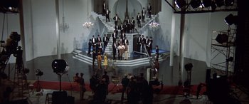 Movie still from “Blazing Saddles” (1974), directed by Mel Brooks – A group of men in suits standing in front of a staircase; Extreme Wide shot, High angle