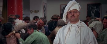 Movie still from “Blazing Saddles” (1974), directed by Mel Brooks – A group of people gathered in a room; Medium shot, Over the shoulder angle