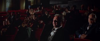 Movie still from “Blazing Saddles” (1974), directed by Mel Brooks – A man sitting in a movie theater in front of many people; Wide shot, High angle