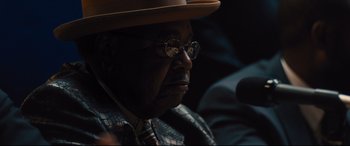 Movie still from “Bleed for This” (2016), directed by Ben Younger – An older man wearing glasses and a hat; Close Up shot, Over the shoulder angle